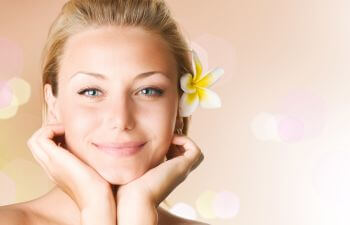 Youthful beautiful woman wearing a flower in her hair.